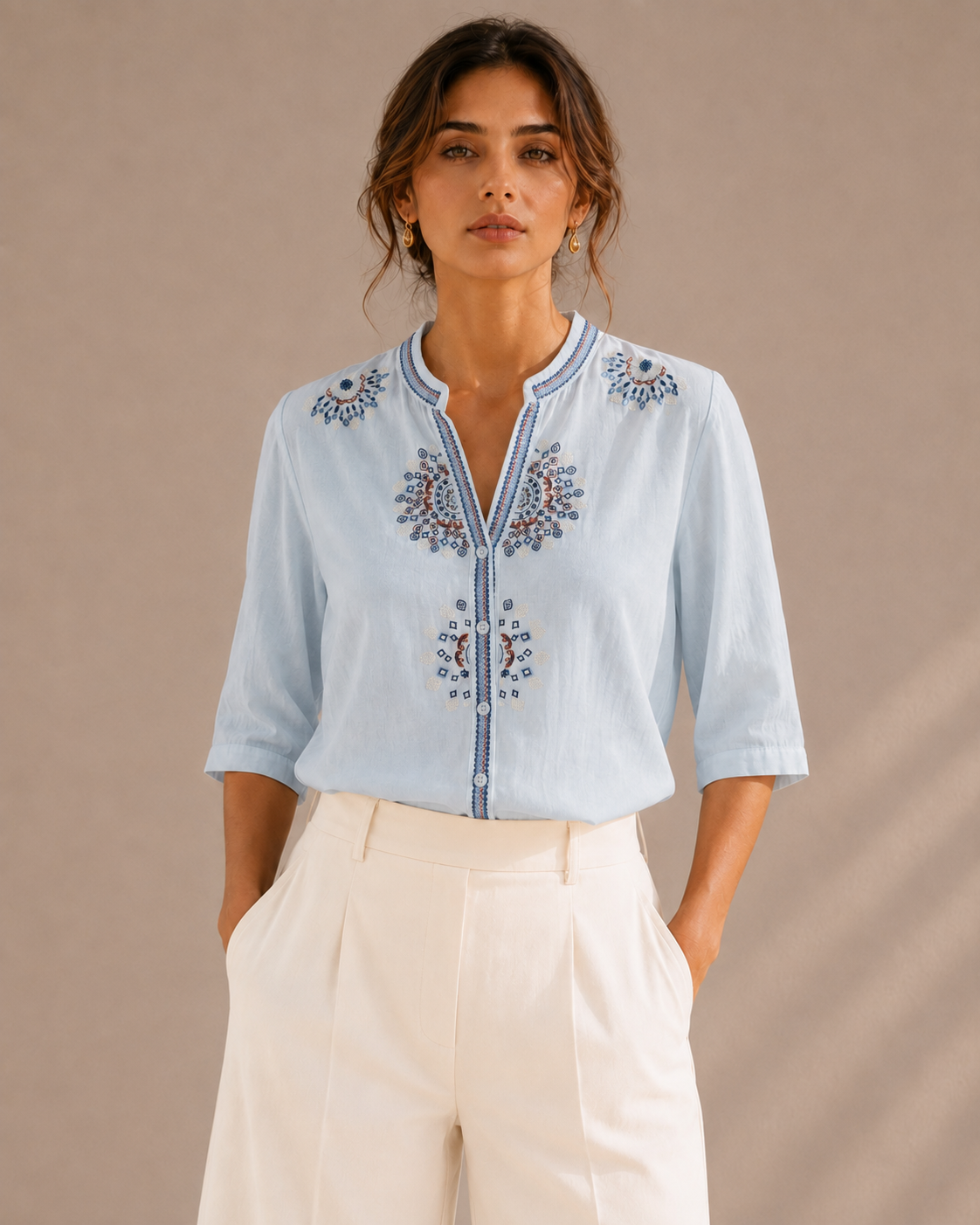 Woman wearing the sky blue medallion embroidered cotton shirt, front view.
