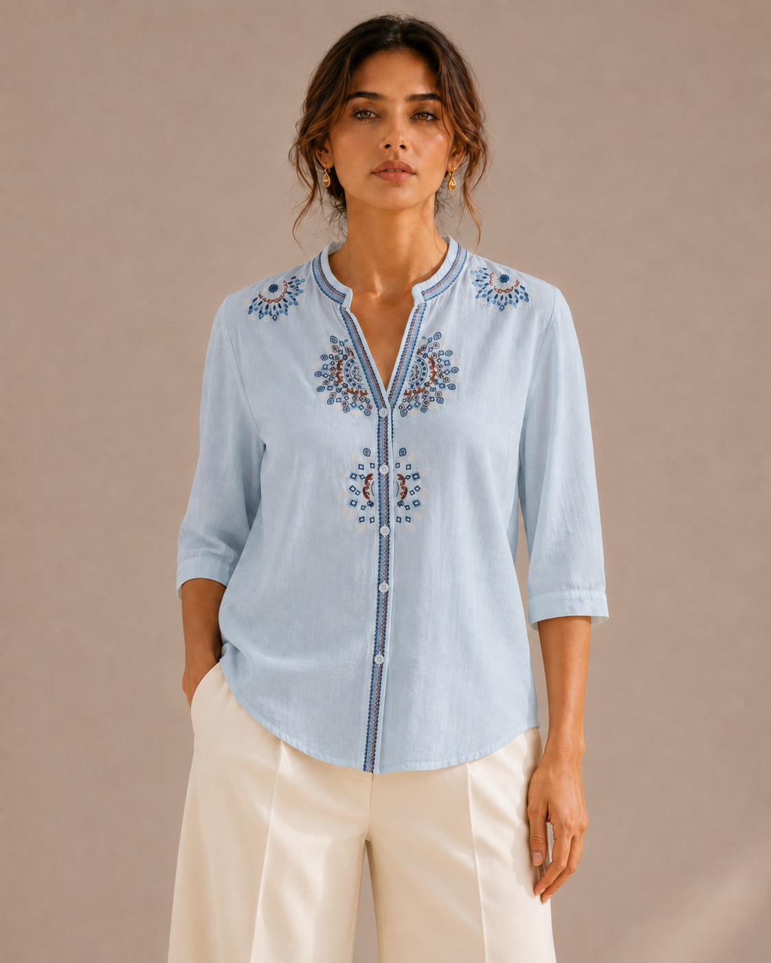 Front view of the untucked sky blue medallion embroidered cotton shirt, showing the full embroidery placement and curved hem.
