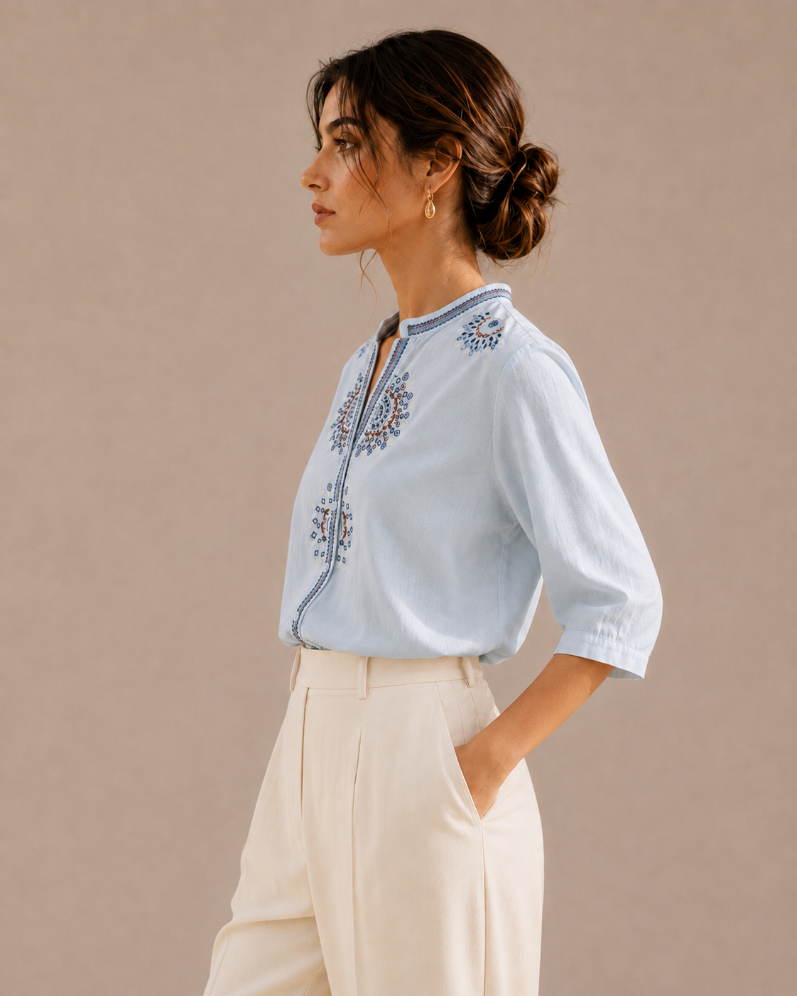 Side profile of a woman wearing the sky blue medallion embroidered cotton shirt, showing the silhouette and embroidery.
