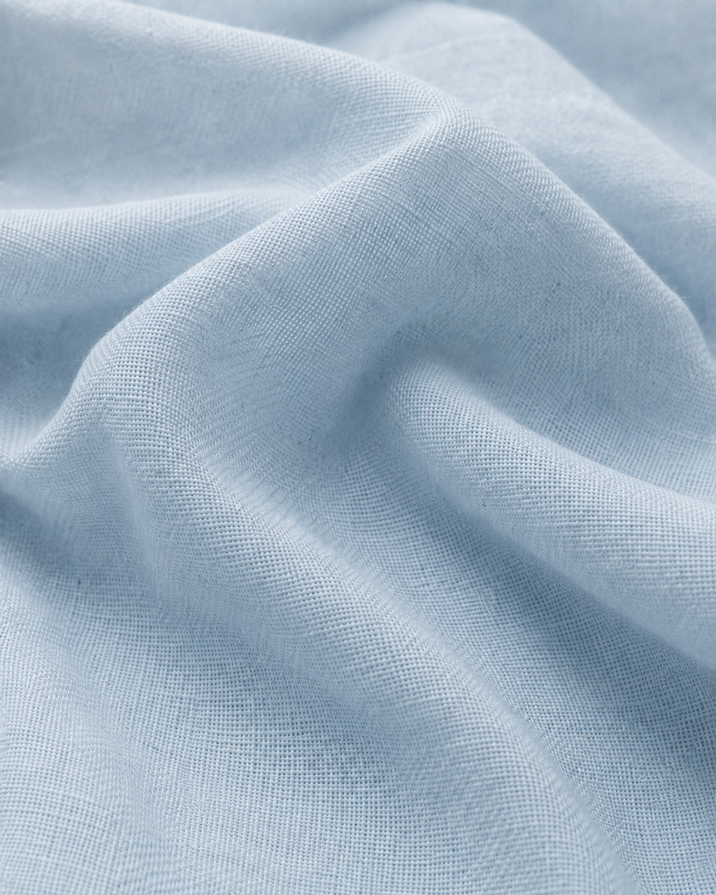 Close-up of the sky blue cotton fabric texture and soft folds.
