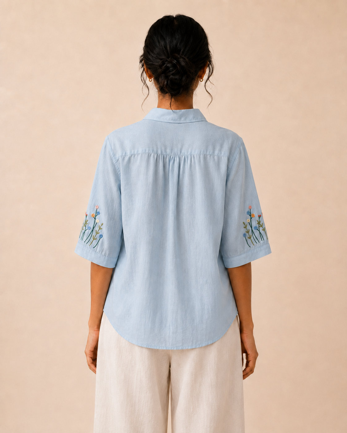 Back view of the sky blue wildflower embroidered cotton shirt, showing the rear yoke and relaxed fit.

