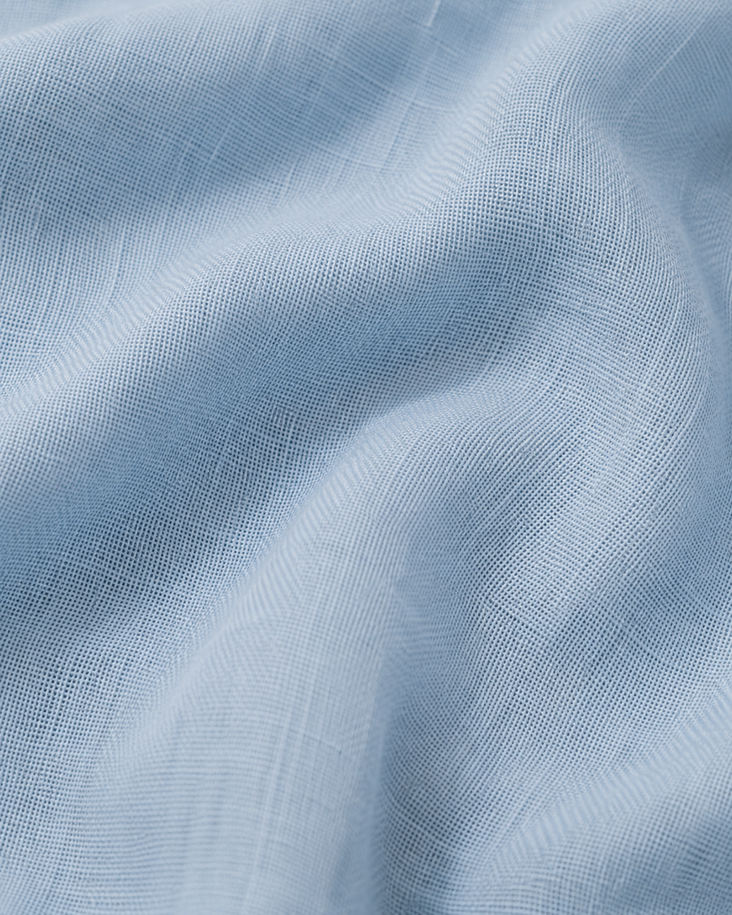 Close-up of the sky blue cotton fabric texture and soft folds.
