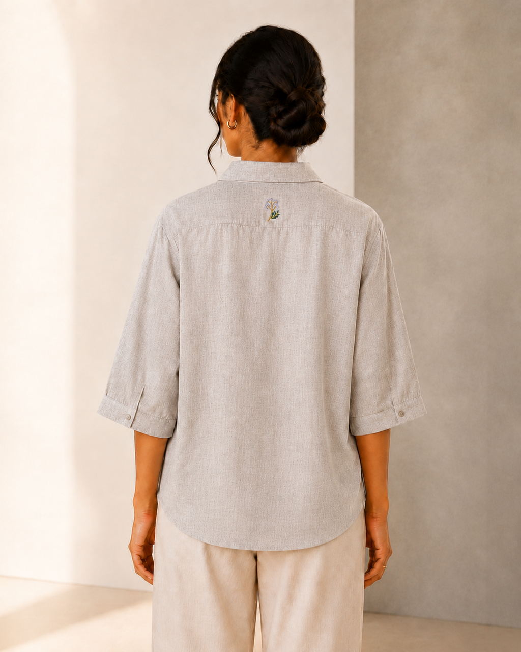 Back view of the stone grey back embroidered embroidered linen shirt, showing the rear yoke and relaxed fit.
