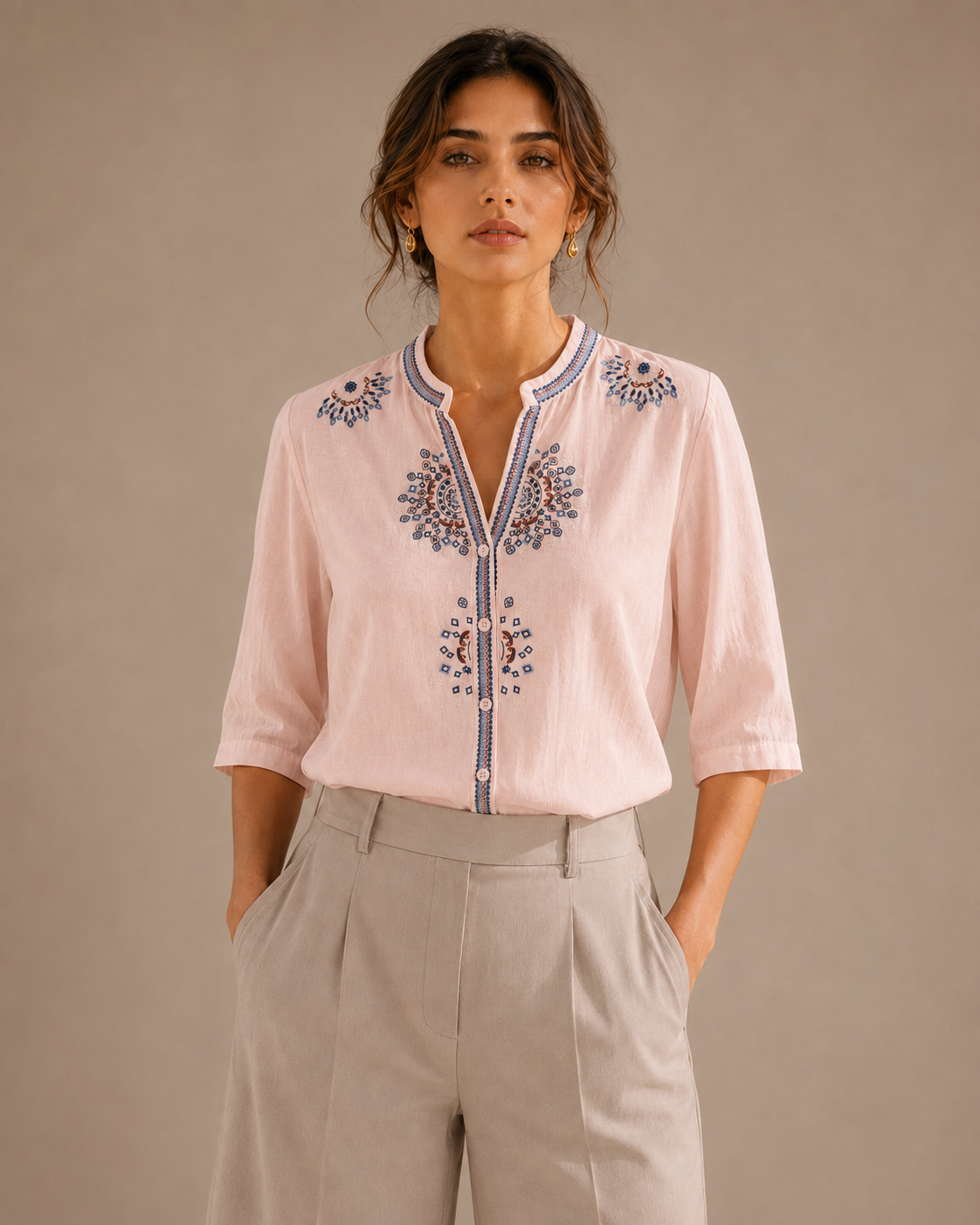 Woman wearing the soft blush pink medallion embroidered cotton shirt, front view.
