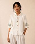 Woman wearing the ivory wildflower embroidered cotton shirt, front view.
