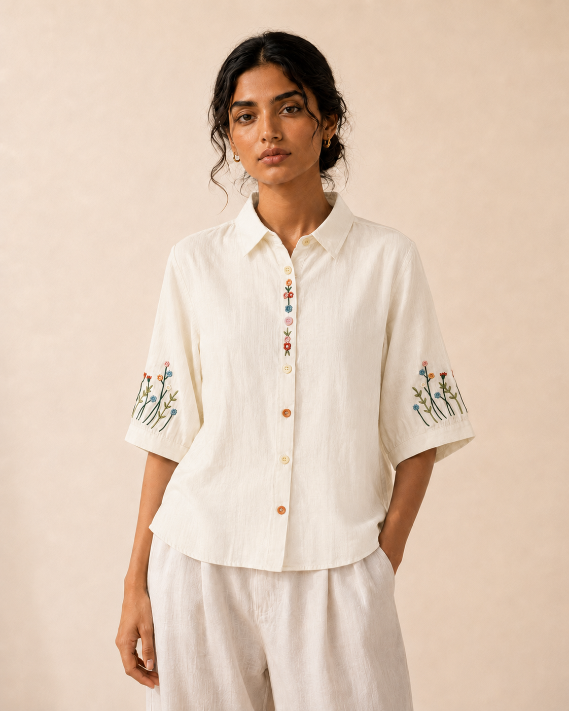 Woman wearing the ivory wildflower embroidered cotton shirt, front view.
