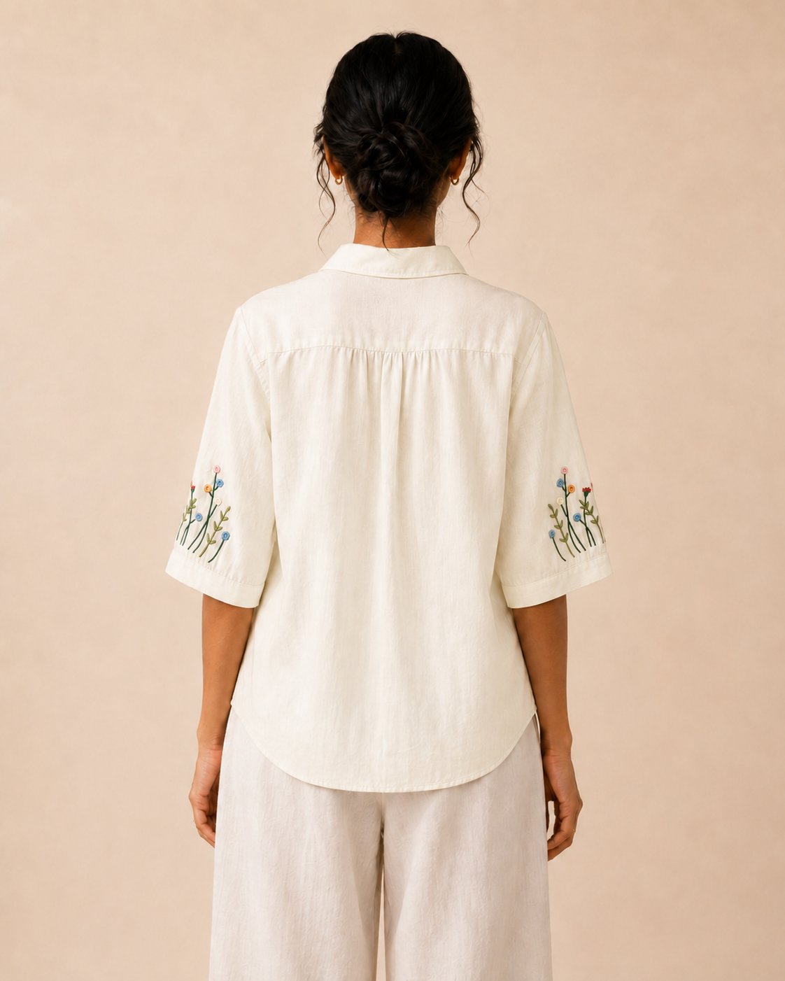Back view of the ivory wildflower embroidered cotton shirt, showing the rear yoke and relaxed fit.
