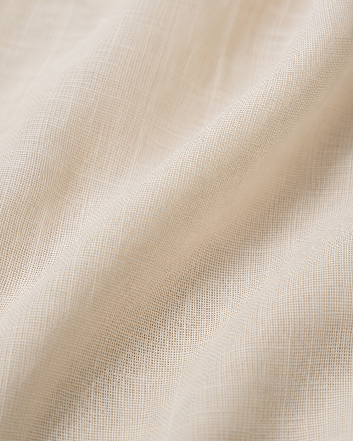Close-up of the ivory cotton fabric texture and soft folds.
