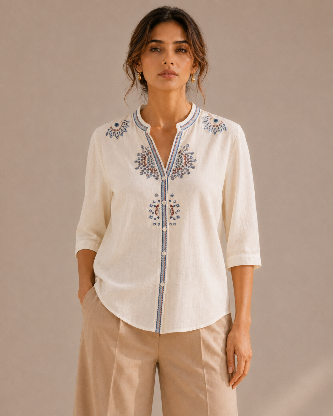 Front view of the untucked warm ivory white medallion embroidered cotton shirt, showing the full embroidery placement and curved hem.
