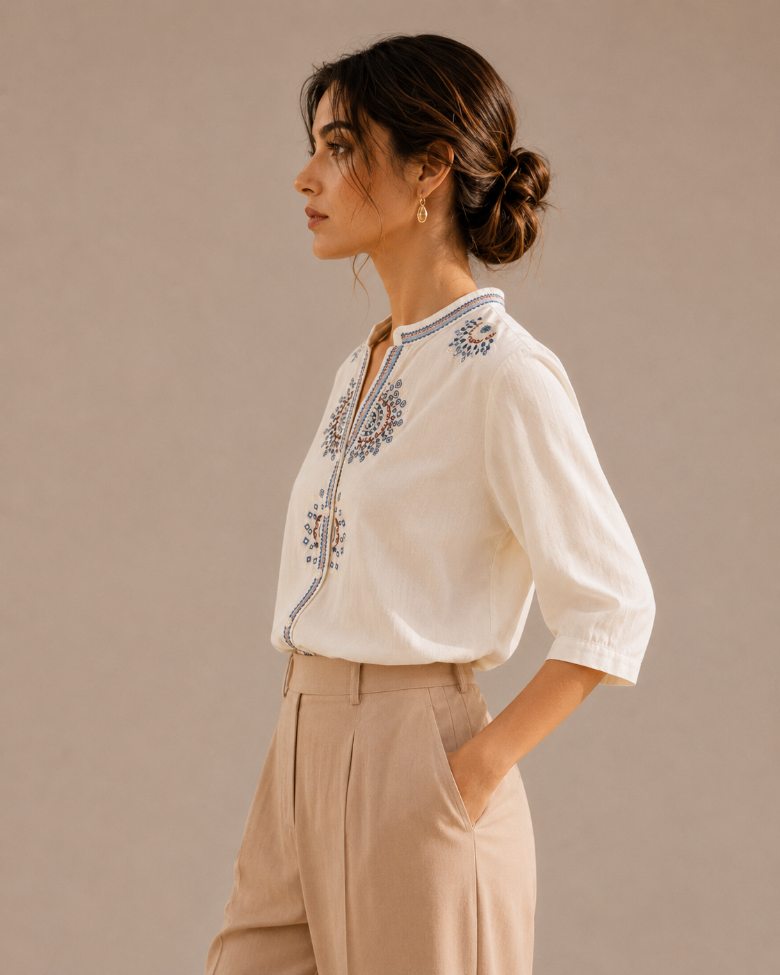 Side profile of a woman wearing the warm ivory white medallion embroidered cotton shirt, showing the silhouette and embroidery.
