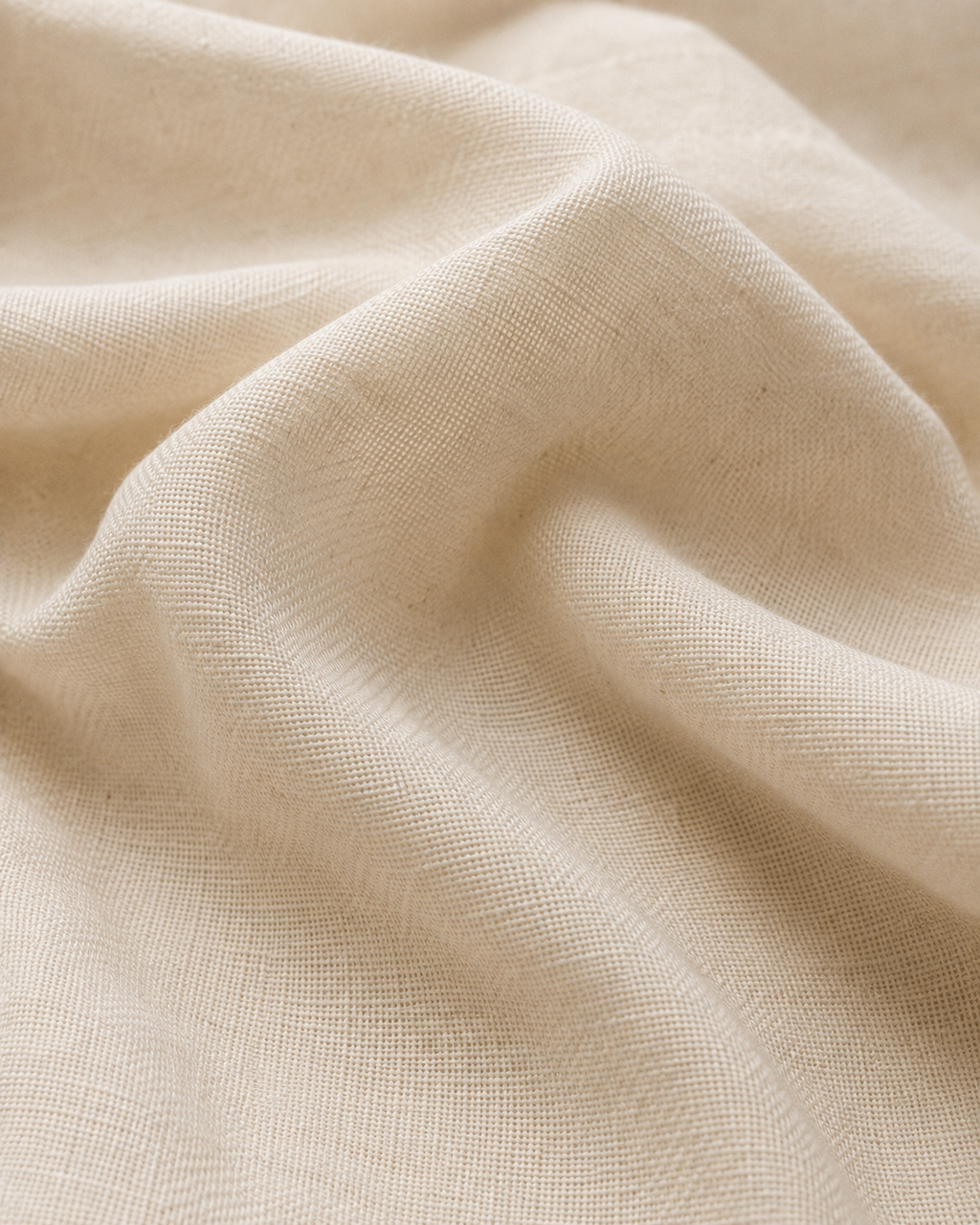 Close-up of the warm ivory white cotton fabric texture and soft folds.
